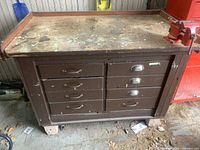 Overview of brown metal tool chest with six drawers and robust work surface showing wear.