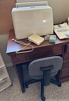 Wooden sewing table with machine case, accessories and grey chair