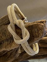 Full view of the silver mesh cuff bracelet with love knot