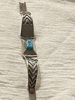 Full view of vintage Navajo sterling silver bracelet showing clasp with rectangular turquoise stone and engraved geometric silver links.