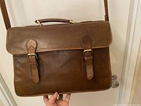 Front exterior view showing fold-over flap with two buckle straps and top handle