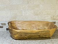 Side view of teakwood root bowl showing natural wood grain and smooth interior surface