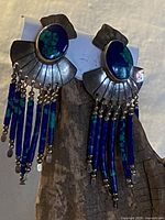 Full front view of the pair of vintage Navajo silver and malachite dangle earrings showing the oval malachite stones, silver fan backings, and blue-green bead tassels