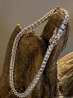 Full length of silver-tone rhinestone tennis bracelet displayed, showing the entire band and stone settings.