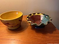 Photo showing both handmade pottery bowls side by side, highlighting their shapes, colors and designs.
