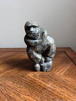 Front view of the small soapstone figurine showing the person seated with hand on chin.