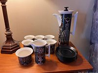 Full view of the 15-piece set including 6 cups, 6 saucers, coffee pot, cream, and sugar pieces with Magic City design.