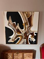 Full view of the abstract mixed media painting on canvas showing organic shapes in black, brown, white, and beige with textural details and gold frame.
