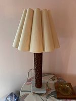 Front view of the vintage wood carved table lamp showing the carved wooden body, Carrara marble base, and off-white sculptural wooden shade with marks.