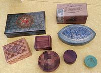 All eight decorative boxes arranged on a yellow surface showing various materials and shapes