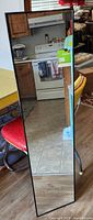 Front view of full length mirror showing clear reflective surface with black frame.
