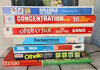 Stack of eight vintage boxed board games showing titles and boxes
