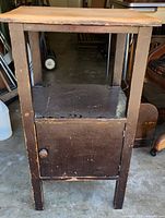Photo of the old wood cabinet front showing the open shelf and cabinet door with wooden knob.