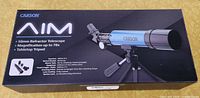 Box showing Carson AIM 50mm Refractor Telescope with magnification up to 78x and tabletop tripod.