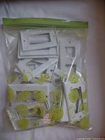 Large plastic bag containing multiple white electrical wall plates with varying opening sizes and configurations.