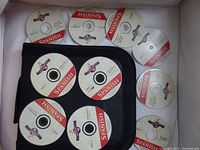Nine Global Access Mastering Spanish language learning DVDs laid out with a black zippered DVD case underneath some discs, no original case present.