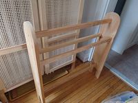 Photo of the front and side angle of the pine quilt or blanket rack showing three horizontal rails and natural wood grain.