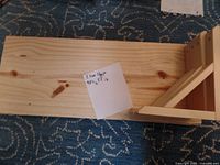 Two pine shelves stacked, showing natural wood grain and knots with a note specifying dimensions 2 feet long by 9.5 inches wide.