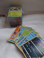 Stack of approximately 250 Pokémon cards in trading card sleeves, with several cards fanned out showing front artwork and stats such as Turtwig and Liepard.