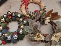 All three wreaths displayed together on floor, showing varying designs and textures