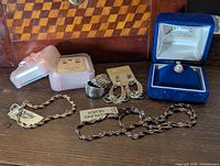 Full jewelry lot displayed on wooden surface including all pieces and boxes.