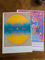 Two Peter Max psychedelic pop art poster prints, one with a large yellow/orange circular design and the other with colorful floral and abstract patterns.