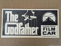 Full view of The Godfather official film car placard with logo and text.