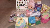 Group photo showing wooden toys, doll, Lego book, Golden Books titles, and other assorted toys