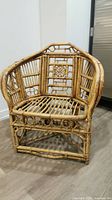 Front view of bohemian rattan chair showing woven pattern details and slatted seat