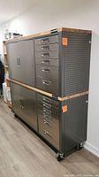 Two stacked MasterCraft metal tool chests on swiveling caster wheels with wooden tops and side pegboard panels