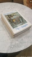 Stack of The Great Artists picture books with Michelangelo cover visible, showing a detailed painting and title text.