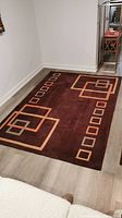 Full view of the wool area rug laid out on floor showing the geometric square pattern and colors.