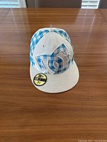 Blue and white DC New Era 59FIFTY fitted hat showing front side with logo and size sticker on bill.
