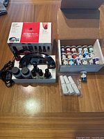 Wide shot of the Gel Polish Pro Kit box, UV lamp, gel polish bottles, and the box of 25 nail foil bottles.