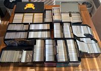 Overhead shot of the table showing multiple open boxes and tins filled with loose bulk Pokémon cards