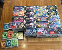 Overview of open white storage trays filled with loose Pokemon trading cards and stacks of sleeved basic energy cards