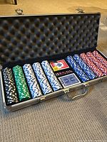 Full view of poker set in open metal case showing chips, cards, dice