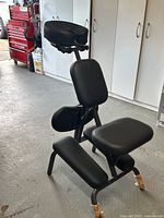 Full view of the portable massage chair showing black padded sections and metal frame