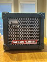 Front view of the Roland Micro Cube amplifier showing the grille with Roland and Micro Cube logos.