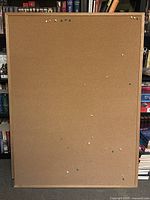 Front view of a large cork board with a wood frame, approximately 3ft by 4ft, showing multiple colored thumbtacks.