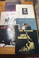Front cover of eight vinyl LP records showing titles and artists including Chris de Burgh, Dan Fogelberg, The Nylons, Glenn Gould, Toronto, and Neil Diamond.