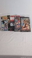 Five comic books standing side by side in bagged sleeves showing covers