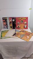 Photo showing multiple vintage vinyl record albums with colorful covers, including Michael Jackson, Jungle Book, and Funtown albums, arranged upright and laying flat.