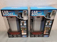 Front and side view of the CAR BOOST portable battery boost system in their original boxes, showing product branding and usage images.