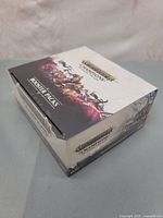 Angle showing front and top of sealed box with artwork and branding.