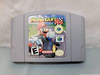 Front of the Nintendo Mario Kart 64 game cartridge showing label with Mario character and title.