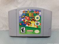 Front view of Nintendo 64 Super Mario 64 game cartridge showing the colorful label with Mario artwork and logos.