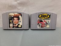 Front view of two Nintendo 64 cartridges Ridge Racer 64 and GoldenEye 007 with colorful labels