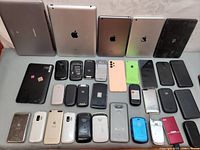 Multiple mobile devices including tablets, smartphones, and feature phones arranged in rows