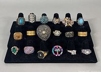 Front view showing all 18 rings arranged on black velvet stand, displaying style variety and condition.